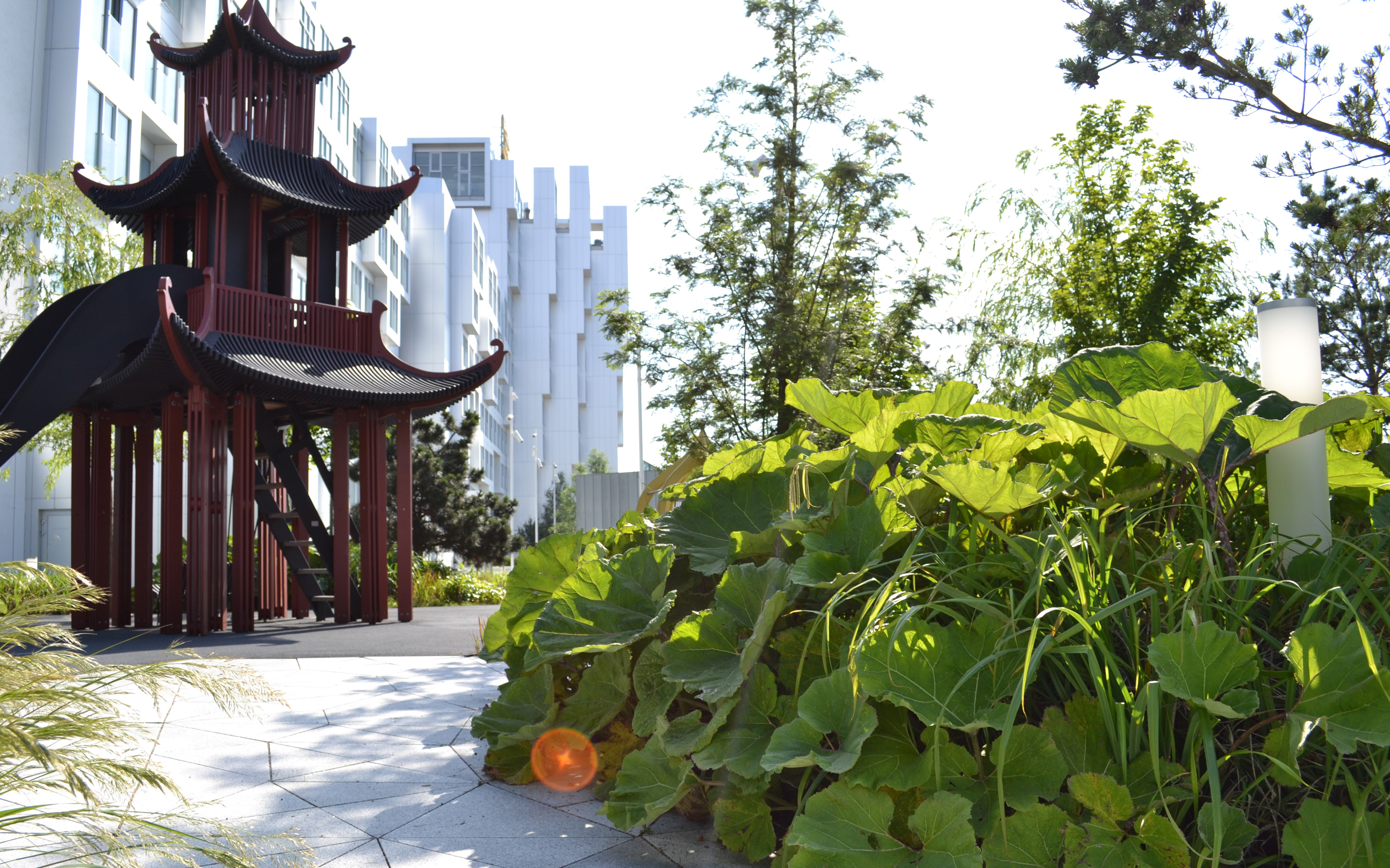 The design of the playground clearly shows an Asian influence. Asian style playhouse for children beside luscious vegetation